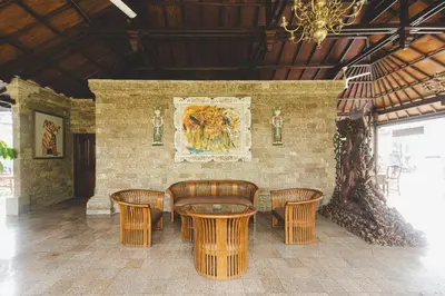 a dining room with a table and chairs and a painting at Sari Bunga Hotel Legian Kuta Bali in Legian