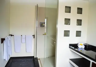 a white bathroom with a shower and a sink at Seminyak Villa Lumina in Seminyak
