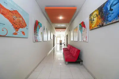 a corridor with a red couch in a hallway at Cityzen Renon Hotel in Denpasar