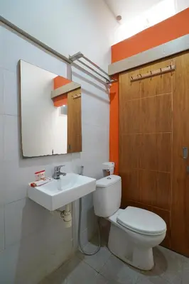 a bathroom with a toilet and a sink at Cityzen Renon Hotel in Denpasar