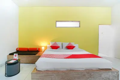 a bedroom with a large bed with red pillows at Cityzen Renon Hotel in Denpasar