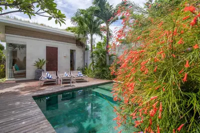 a backyard with a swimming pool and a house at Villa K-Mea in Seminyak