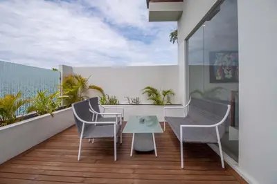 a balcony with a table and chairs and the ocean at Villa K-Mea in Seminyak