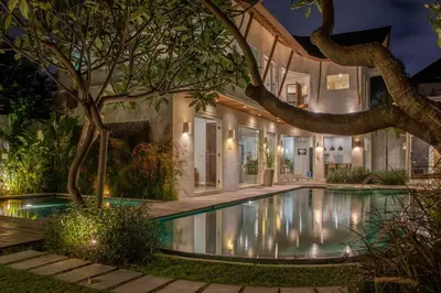 a swimming pool in the yard of a house at night at Villa K-Mea in Seminyak