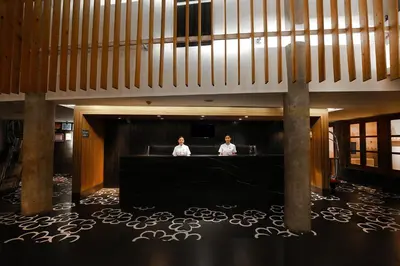 two men sitting at a table in a large room at THE 1O1 Bali Fontana Seminyak in Legian
