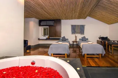 a room with three beds and a bath tub with red flowers at THE 1O1 Bali Fontana Seminyak in Legian