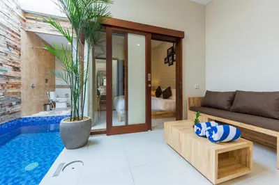 a living room with a pool and a couch at Paisa Seminyak Living in Seminyak