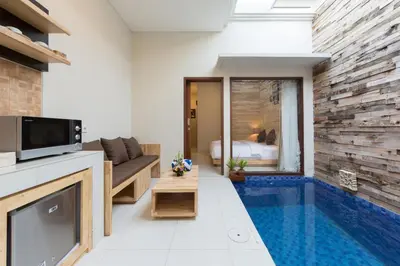 a living room with a swimming pool in a house at Paisa Seminyak Living in Seminyak
