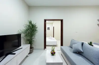 a living room with a couch and a tv at Paisa Seminyak Living in Seminyak