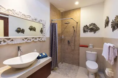 a bathroom with a sink and a toilet and a shower at Villa Kamboja Five in Seminyak