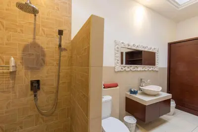 a bathroom with a shower and a toilet and a sink at Villa Kamboja Five in Seminyak