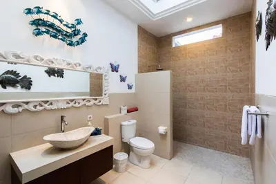 a bathroom with a sink and a toilet at Villa Kamboja Five in Seminyak