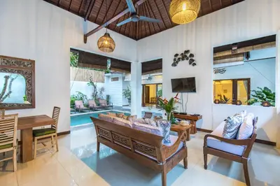 a living room with a couch and a table at Villa Kamboja Five in Seminyak