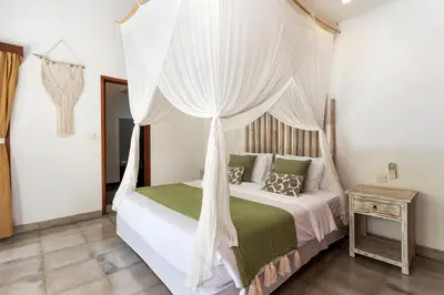 a bedroom with a bed with a canopy at Villa Cinta Umalas in Canggu