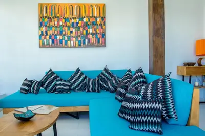 a blue couch with black and white pillows on it at Villa Orked 2 in Seminyak