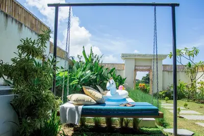 a swing in a garden with pillows at Villa Orked 2 in Seminyak