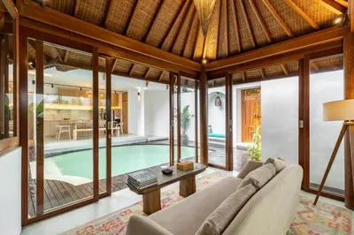 a living room with a couch and a table in front of a pool at The Lagoon Canggu in Canggu