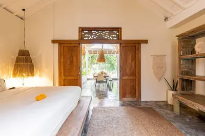 a bedroom with a large bed and a table at Oma Villa - A tropical sanctuary of Seminyak in Seminyak