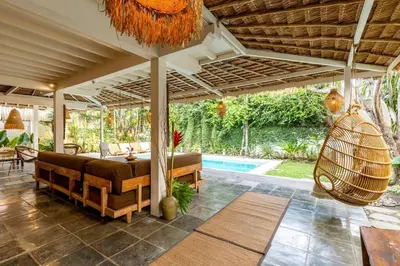 a patio with a couch and a hammock and a pool at Oma Villa - A tropical sanctuary of Seminyak in Seminyak