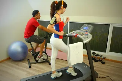 a man and a woman on a treadmill in a gym at Rhadana Hotel in Kuta