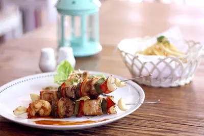 a plate of food with meat and vegetables on a table at Rhadana Hotel in Kuta