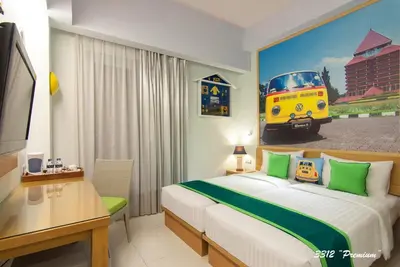 a hotel room with a bed and a painting of a bus at Rhadana Hotel in Kuta