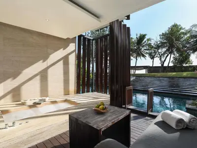 a living room with a table and a pool at Grand Seminyak Lifestyle Boutique Bali Resort in Seminyak