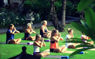 a group of people sitting on the grass in a park at Truntum Kuta Bali in Kuta