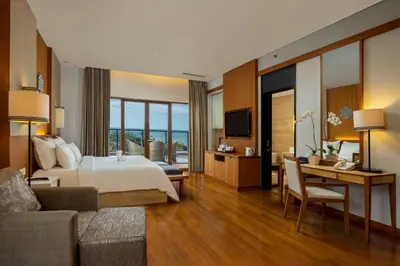 a large hotel room with a bed and a desk at Truntum Kuta Bali in Kuta