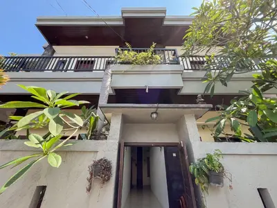 a building with a balcony with plants on it at Adi surya guest house in Seminyak