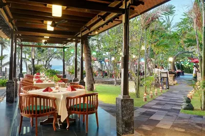 a restaurant with a table and chairs in a pavilion at Legian Beach Hotel in Legian