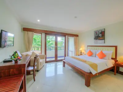 a bedroom with a bed and a desk and a couch at Hotel Vila Lumbung in Seminyak