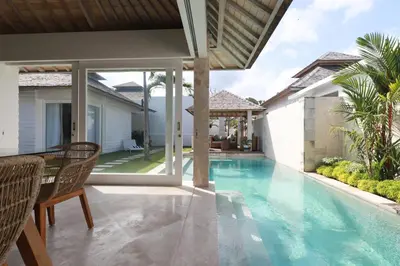 a swimming pool in a villa with a table and chairs at The Plantation at Batu Belig in Canggu