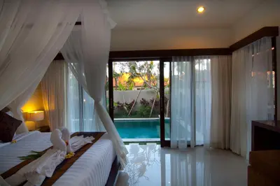 a bedroom with a bed and a swimming pool at The Awan Villas Seminyak in Seminyak