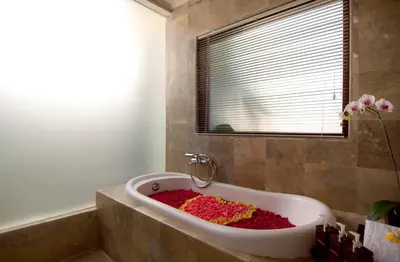 a bathroom with a bath tub filled with flowers at The Awan Villas Seminyak in Seminyak