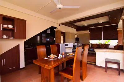 a kitchen with a wooden table and chairs at The Awan Villas Seminyak in Seminyak
