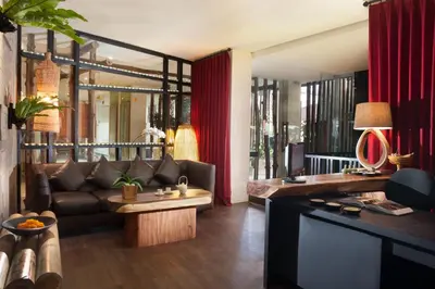 a living room with a couch and a table at Grandmas Plus Hotel Legian in Legian