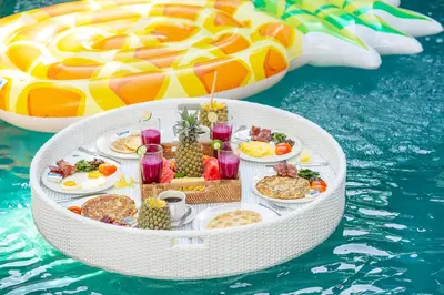 a table of food on a raft in the water at Villa Love Umalas in Kerobokan