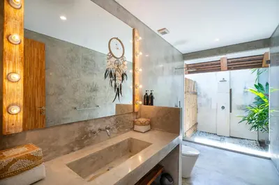 a bathroom with a tub and a clock on the wall at Villa Love Umalas in Kerobokan