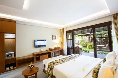 a hotel room with a bed and a television at The Astari Villa and Residence in Jimbaran