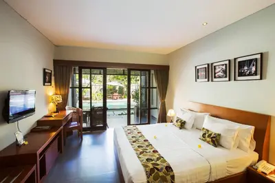 a bedroom with a bed and a desk and a television at The Astari Villa and Residence in Jimbaran