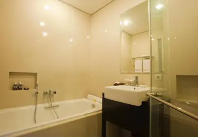 a bathroom with a sink and a tub and a mirror at The Astari Villa and Residence in Jimbaran