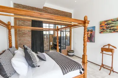 a bedroom with a wooden canopy bed with pillows at Villa Maje by Alfred in Bali in Seminyak