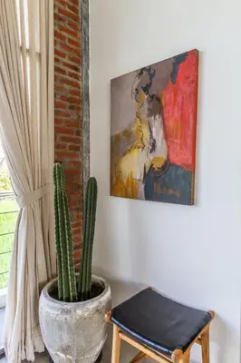 a cactus in a pot in a room with a painting at Villa Maje by Alfred in Bali in Seminyak