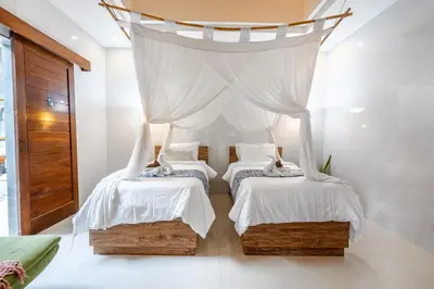 two beds in a room with a canopy at Kubu Joglo Villa in Seminyak