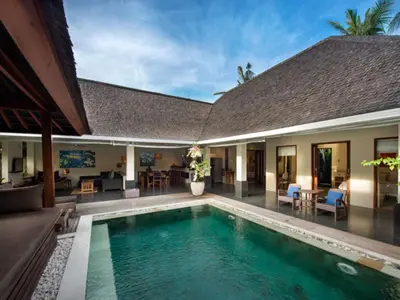 a villa with a swimming pool and a house at Anyar Estate in Canggu