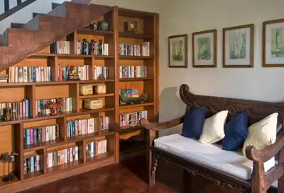a living room with a couch and book shelves filled with books at Anyar Estate in Canggu