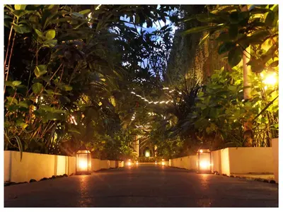a street at night with lights and trees at Arana Suite in Legian
