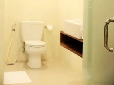 a bathroom with a white toilet and a sink at Arana Suite in Legian