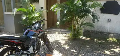 a motorcycle parked in front of a house with palm trees at Alamanda Villa in Seminyak